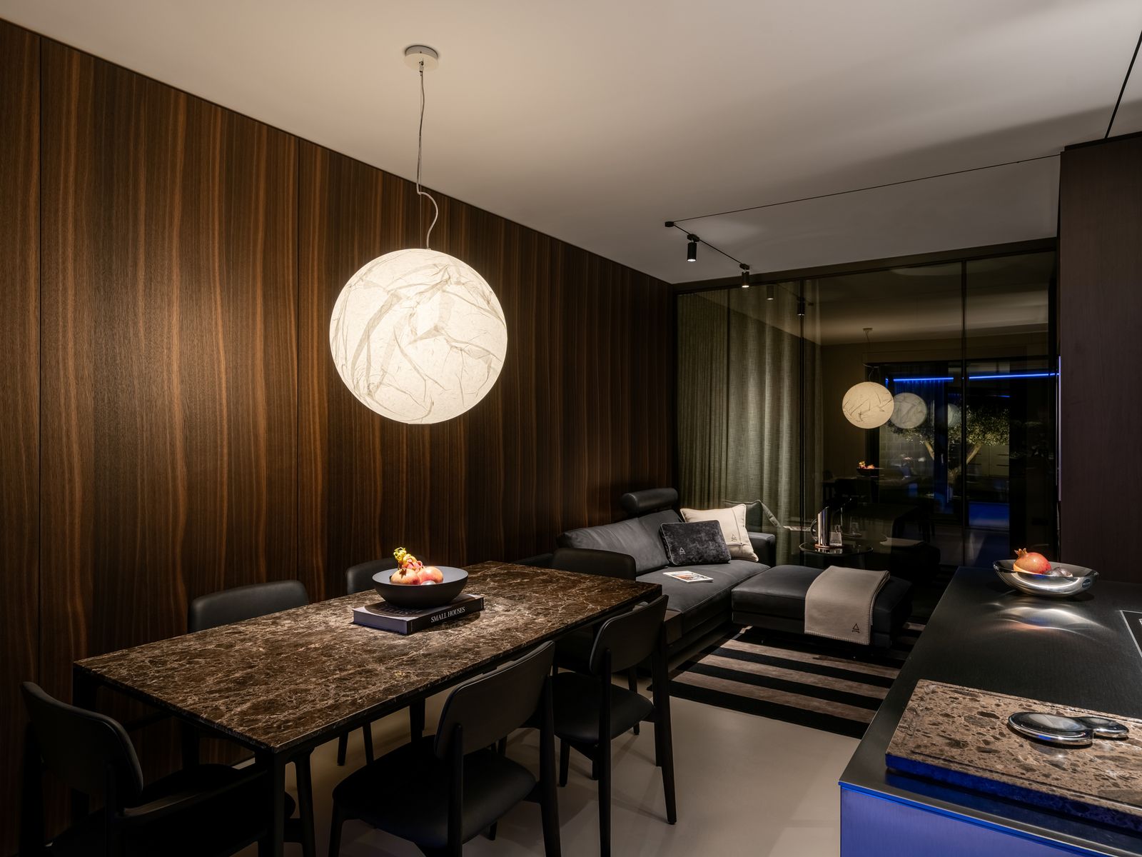 Cucina Poliform di ShangriLux: piano in pietra, luce calda, mise en place.