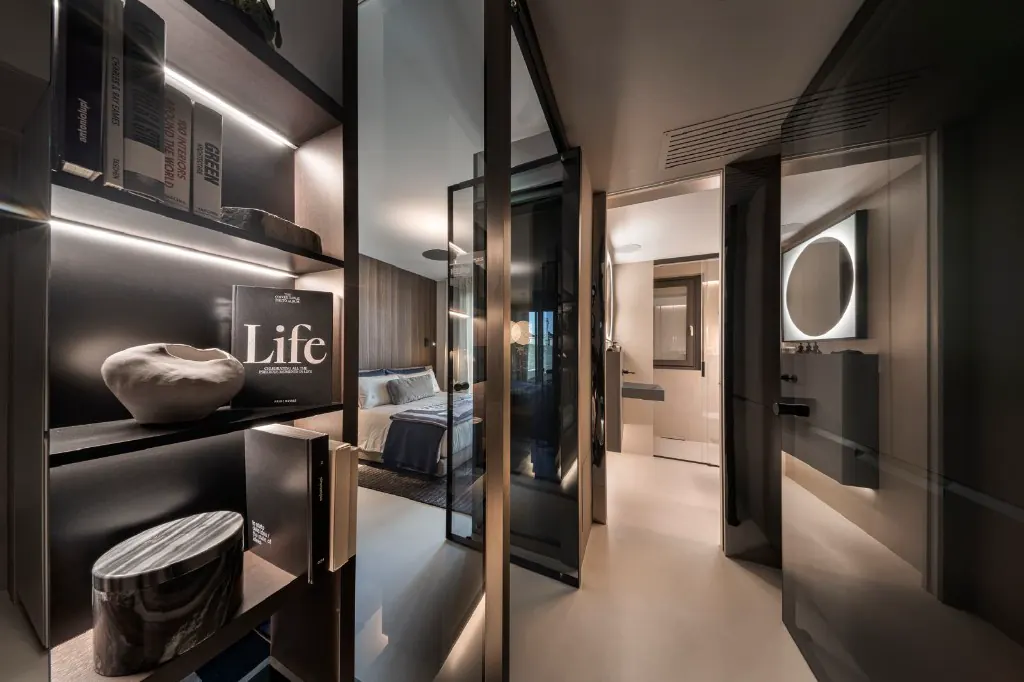 Couloir vers salle de bain et chambre : bibliothèque éclairée et design italien.