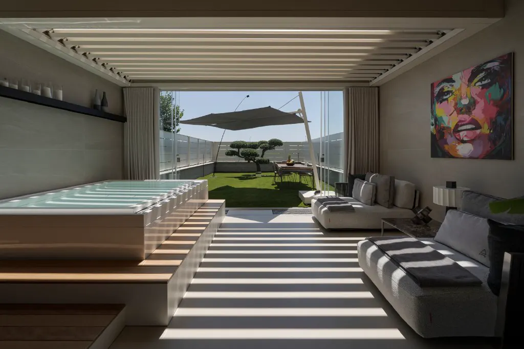 Espace spa diurne : mini-piscine, lounge et jardin d’hiver derrière les verrières.