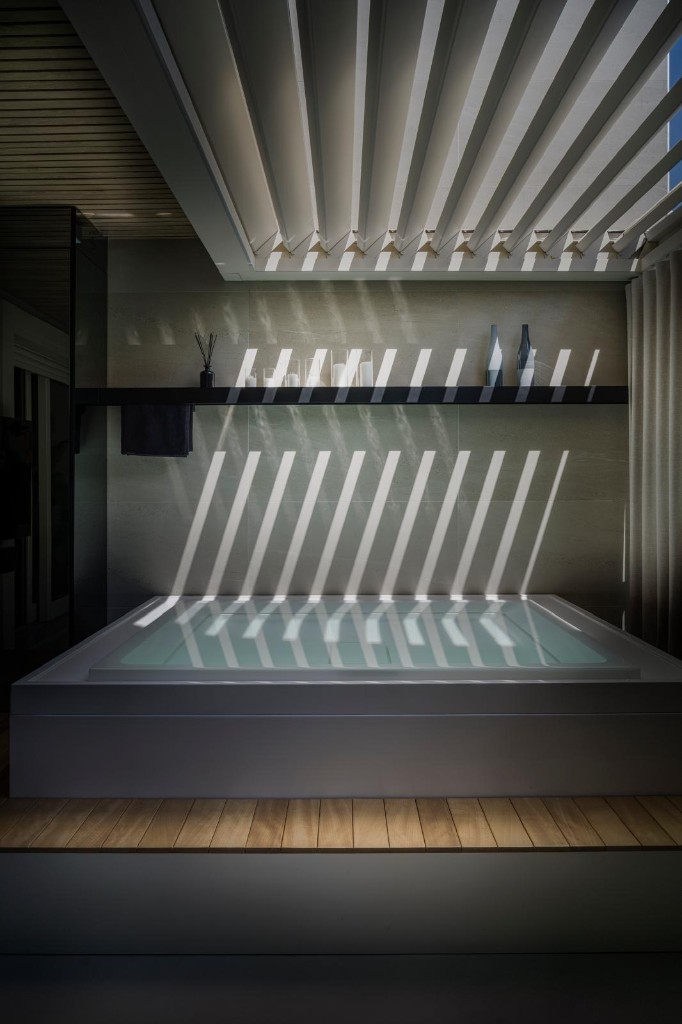 Mini-piscina ShangriLux: ombre del pergolato sull’acqua e shelf con candele.