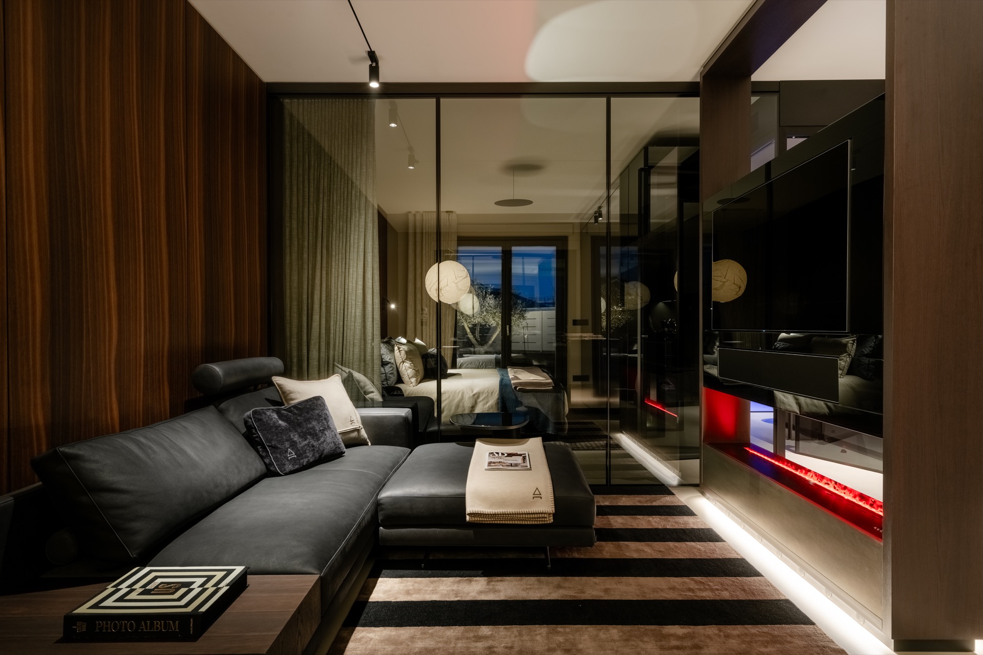 Il living ShangriLux: divano in pelle, camino a vapore e vetrata verso la zona notte.